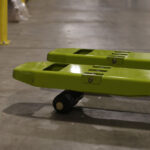 Close-up of the fork tips and load wheels on a Clark electric pallet truck, highlighting the low-profile fork design used for smooth pallet entry and material handling in warehouse environments.