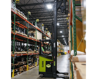 Clark NPX 17 order picker operating in a warehouse aisle, lifting an operator to access inventory stored on tall industrial shelving racks.